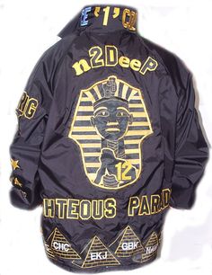 the back of a jacket with an egyptian pharaoh design on it, and gold lettering