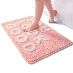 a person standing on a pink rug with the word book written in white