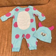 a baby's blue and pink polka dot footie with matching hat on a couch