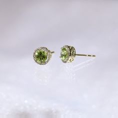 "These stylish earrings have a stunning bright color and the Peridot is surrounded by a halo of shimmering diamonds. Perfect as a gift for a girlfriend or wife or mother. * Made to Order. * Metal: 925 Sterling Silver * Custom Color: Yellow Gold Plated, Rose Gold Plated, Silver * Main Stone: Peridot, 5mm dia Round Shape, 2pcs * Side Stone: Cubic Zirconia * Metal: 9K * Custom Color: Yellow Gold, Rose Gold, White Gold * Main Stone: Peridot, 5mm dia Round Shape, 2pcs * Side Stone: Cubic Zirconia, 36 Fine Jewelry Green Halo Earrings, Halo Green Fine Jewelry Earrings, Green Halo Earrings For Anniversary, Green Halo Earrings Fine Jewelry, Yellow Gold Peridot Jewelry With Halo Setting, Round Peridot Gemstone Earrings, Peridot Gemstone Round Earrings, Peridot Gemstone Earrings, Birthstone Engagement Rings