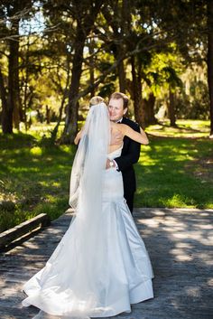 a bride and groom embracing on a path