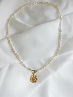 Genuine AA freshwater rice pearls, high quality 14k gold filled Saint Christopher pendant & toggle clasp. Length: approximately 19” Genuine 4-5mm freshwater pearls, 14k gold filled beads and findings Pendant: 20mm Gold filled toggle clasp Does not tarnish, turn, or rust. 14k gold filled, never plated. Water-resistant. Each natural pearl is unique and therefore no two are alike. Pearls, colors and sizes may vary. Handmade with the highest standards & quality materials. Includes 100% organic cotto Gold Pearl Necklace With Toggle Clasp, Gold Pearl Drop Toggle Necklace, Gold Toggle Necklace With Pearl Pendant As Gift, Gold Pearl Toggle Necklace With Pearl Chain, Gold Toggle Necklace With Pearl Chain, Gold Pearl Toggle Necklace With Pearl Drop, Gold Pearl Toggle Necklace Gift, Gold Toggle Necklace With Pearl Drop, Gold Pearl Toggle Necklace