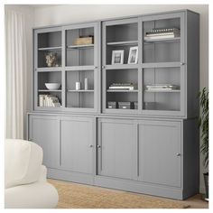 a living room with gray bookcases and white furniture