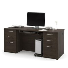 an office desk with a computer on top of it and a monitor sitting on top of the desk