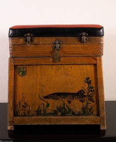 an old wooden box with a fish painted on it