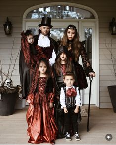 a family dressed up for halloween standing in front of a house