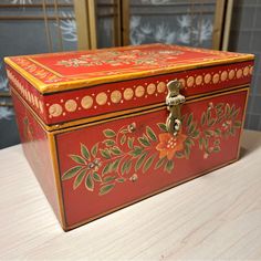 an ornately painted box sits on a table in front of a wall with windows