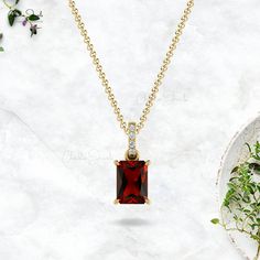 Description This stunning AAA quality Gold Garnet Pendant with the dazzling white diamond Dangling of I1-I2/G-H clarity & color is crafted in 14k solid gold. An Emerald Cut Octagon Garnet gemstone set with 4-prong settings surrounded with diamonds. Garnet is an official birthstone for the month of January and a symbol of balance, hope, and peace. The 7X5mm Octagon gemstone is flanked by 4 pcs of dazzling 1.10mm white diamonds together to create a Dangling frame. The gold chain shown in the pictu October Birthstone Necklace, Diamond Wedding Jewelry, Garnet Pendant, Garnet Jewelry, Gold Diamond Necklace, Birthstone Pendant, Amethyst Pendant, Garnet Gemstone, Natural Emerald