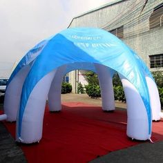 an inflatable arch is set up on a red carpeted area with white and blue arches