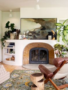 a living room filled with furniture and a fire place next to a painting on the wall