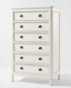 a white chest of drawers with brass knobs on the top and bottom, against a white background