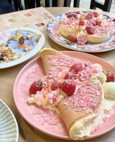 two plates with desserts on them sitting on a table next to paper plates filled with pastries