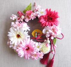 a pink and white wreath with flowers on it