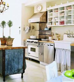 a kitchen with an island in the middle of it and lots of shelves on the wall