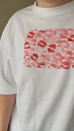 a person wearing a white t - shirt with red paint on it