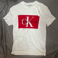 Size S New With Tags Calvin Klein Crew Neck T-shirt For Spring, Casual Red Calvin Klein Tops, Red Short Sleeve T-shirt With Logo, Calvin Klein Logo Cotton Tops, Calvin Klein Cotton Logo Tops, Calvin Klein White Logo Print T-shirt, Calvin Klein Cotton Tops With Logo, Calvin Klein White T-shirt For Streetwear, Calvin Klein Graphic Tee Short Sleeve T-shirt