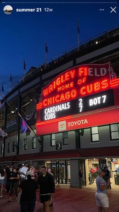 people are standing in front of the wrigley field home of the chicago cubs