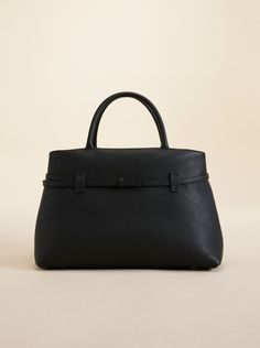 Introducing the latest addition to the Manu Atelier signature pieces, the Le Cambon 35 - a fusion of simplicity and artistry crafted to effortlessly fit into your daily life. Designed with calf skin leather, this bag blends sophistication with practicality, accommodating a 13-inch MacBook and offering a spacious, softly structured shape for all your essentials. Evolved from the design of Tote du Jour, it transforms the daily bag into a more classic and sophisticated version. With refined contour Timeless Structured Bag With Smooth Grain, Classic Structured Textured Leather Bag, Modern Pebbled Leather Satchel For Office, Structured Calf Leather Bag, Structured Soft Calf Leather Bag, Structured Textured Leather Business Bags, Sleek Textured Leather Top Handle Bag, Chic Pebbled Leather Satchel With Leather Handles, Sleek Textured Leather Office Bags