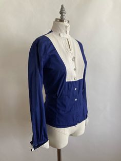 "Unusual tuxedo style 1940s handmade blouse is made with a navy cotton and a white waffled cotton for the collar, chest and cuffs. Shell buttons adorn the neck and lower bodice of the shirt, while metal and glass buttons detail the bib front and (doubled)cuffs. Pleating in the back and front of the bodice give the blouse a bit of shape. Blouse is in good condition, there is a yellow stain in the back of the neck that I have not been able to remove(though I'll give it another try however, it is n Fitted Cotton Tops With Sailor Collar, Fitted Navy Vintage Tops, Fitted Vintage Navy Tops, Fitted Tops With Sailor Collar For Spring, Fitted Cotton Blouse For Vintage Fashion, Handmade Blouse, Tuxedo Style, Acrylic Sweater, Silk Chiffon Dress