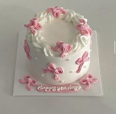 a white cake with pink decorations on top