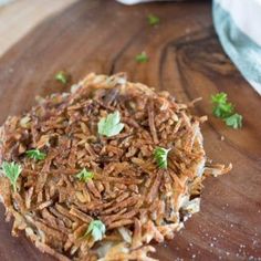 a pile of fried food sitting on top of a wooden cutting board with parsley