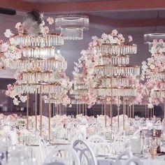 the tables are set with white linens and crystal chandeliers for an elegant wedding reception