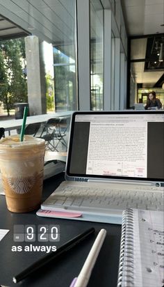 an open laptop computer sitting on top of a table next to a cup of coffee