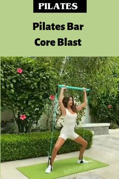 a woman in white shirt and shorts doing pilates bar core blast on green mat