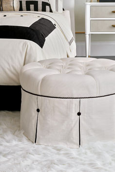 a white ottoman sitting on top of a bed