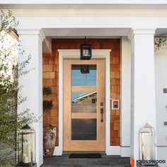 a front door with two lanterns on either side