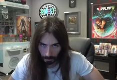 a man with long hair sitting in an office