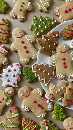 many decorated cookies are on a plate next to some trees and snowflakes