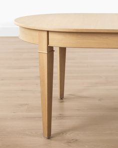 a wooden table with two legs and a round top on a hard wood flooring area