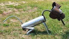 a metal object that looks like a horse's head on top of a stand in the grass