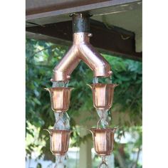 three copper colored lights hanging from a roof