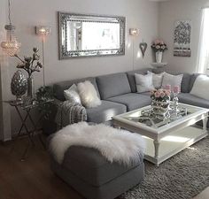 a living room filled with lots of furniture next to a large mirror on the wall