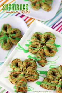 shamrock cookies with green icing on a white plate