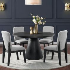 a round dining table with six chairs around it and a vase on the center piece