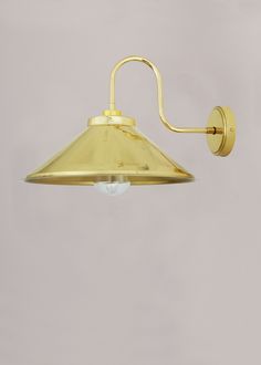 an old fashioned brass wall light on a gray background