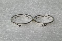 two silver rings with i love you written on them