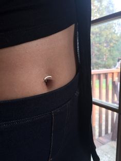 a woman's stomach with a tiny ring on it, and the bottom half of her belly