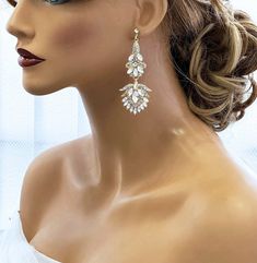 a mannequin head with earrings on it's face, wearing a white dress