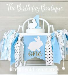 a blue and white birthday cake stand with a bunny on it