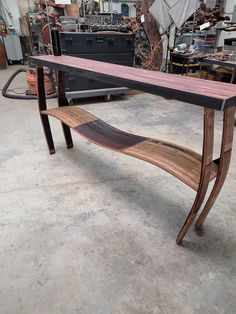 a wooden bench sitting on top of a floor next to a pile of wood furniture