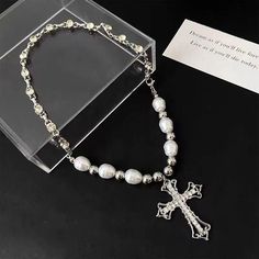 Our cross pearl necklace, suspended from a 39cm chain, exudes an air of elegance. Its refined design makes it an ideal gift for special occasions, delivered right to your doorstep in an exquisite gift box. Chain length 39cm (15inch) Elegant design Shipped with gift box White Cross Pendant Necklace With Clavicle Chain, White Cross Necklace With Clavicle Chain, Elegant Silver Cross Necklace, Pearl Drop Cross Pendant Necklace For Gift, Pearl Drop Cross Necklace Gift, White Cross Necklace With Pearl Charm, Elegant Cross Pendant Necklace With Pearl Drop, Elegant Cross Necklace With Pearl Pendant, Elegant Cross Necklace With Pearl Drop