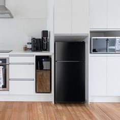 a black refrigerator freezer sitting inside of a kitchen next to a stove top oven