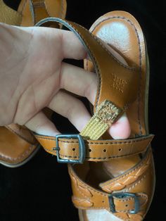 Very funky 1950's brown leather sandals with wooden cut out wedge heels. Bottoms are a soft black material, one shoe is missing a chunk of the soft bottom by the heel, shown in photo. I have not repaired. Wood heels have some scratches. Being sold as is Women's size 5 Vintage Closed Toe Sandals With Leather Footbed, Vintage Open Toe Sandals With Buckle, Vintage Open Toe Sandals With Buckle Closure, Retro Sandals With Leather Footbed And Round Toe, Retro Closed Toe Sandals With Leather Sole, Vintage Leather Sandals With Round Toe, Vintage Leather Footbed Open Toe Sandals, Brown Leather Footbed Open Toe Huarache Sandals, Brown Open Toe Huarache Sandals With Leather Footbed