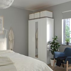 a bedroom with white furniture and a blue chair