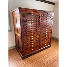 an old wooden cabinet with many drawers on it's sides in a room that has wood flooring