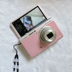 a pink camera sitting on top of a white table